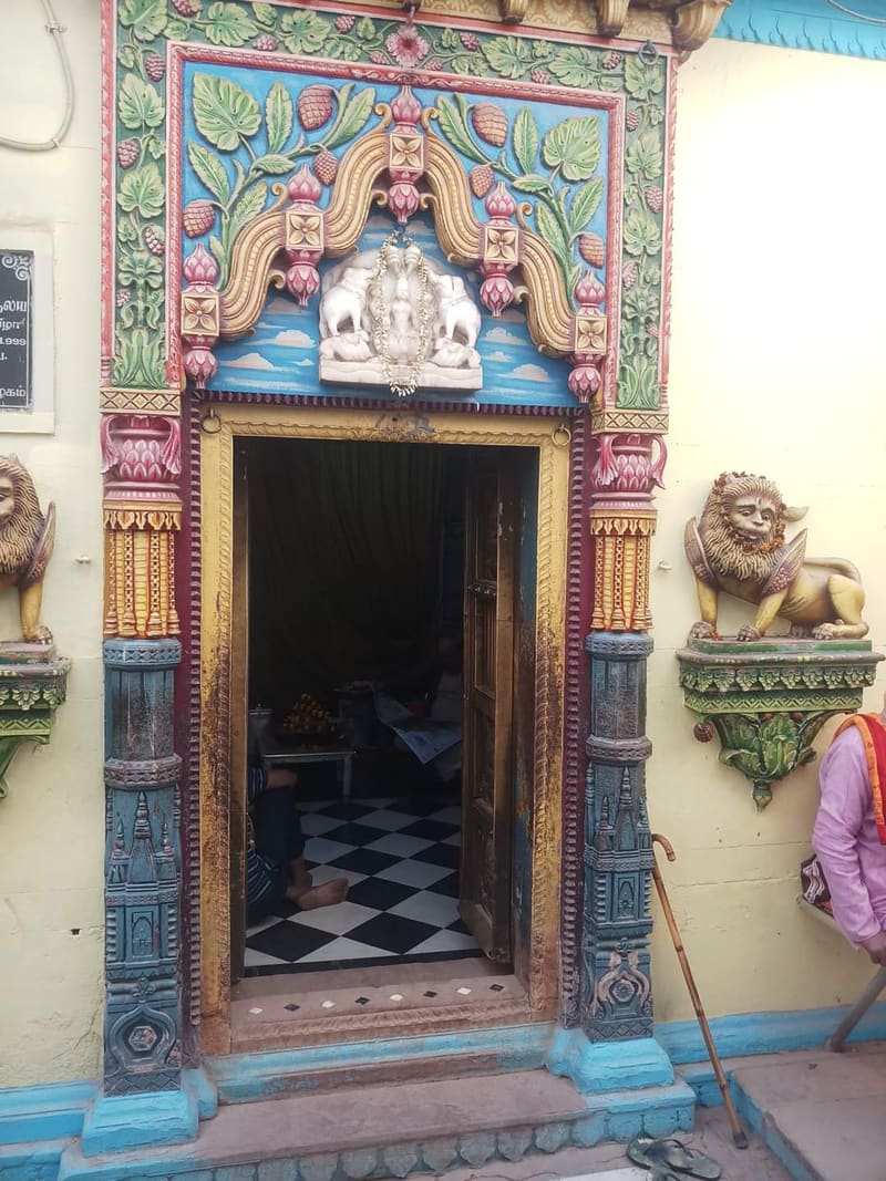 The painted entrance of Vishalakshi Temple, with carved lions on either side of the doorway